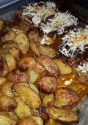 A picture of Baby Potatoes with Pork Neck Chops in the Oven 🥩🥔.