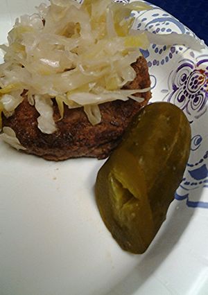 A picture of Sauerkraut on a burger.