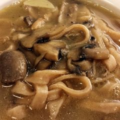 A picture of Udon soup with meat or whatever.
