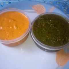 A picture of Red tomato and green chutneys.