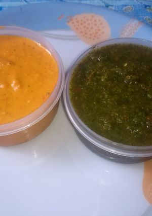 A picture of Red tomato and green chutneys.