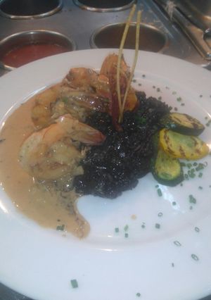 Una foto de Langostinos con risotto marea negra