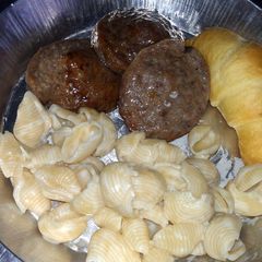 A picture of shells and cheese with sausage.