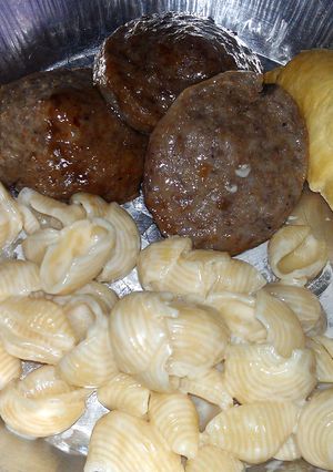 A picture of shells and cheese with sausage.