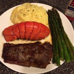 A picture of Thin cut New York strip with lobster and asparagus.