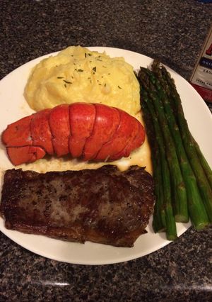 A picture of Thin cut New York strip with lobster and asparagus.