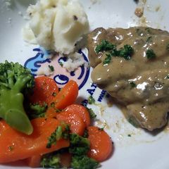 A picture of pork chops with mushroom cream sauce.