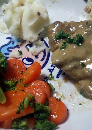 A picture of pork chops with mushroom cream sauce.