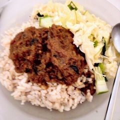 A picture of Cinnamon-Coconut flavored local(ofada) rice with goat meat stew.