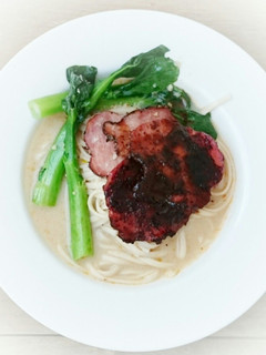 A picture of Udon Noodle With Choy Sum And Black Pepper Ham In Milk Soup.