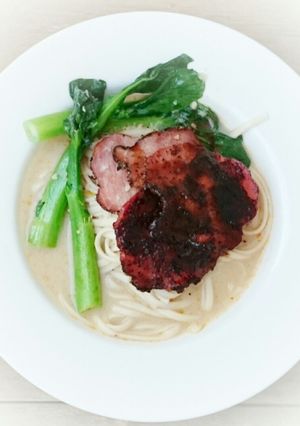 A picture of Udon Noodle With Choy Sum And Black Pepper Ham In Milk Soup.