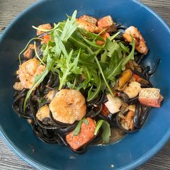 A picture of Seafood Squid Ink Pasta with Prawn Broth.