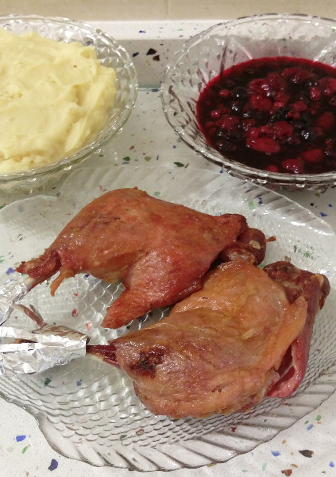 Una foto de Muslos de pato confitado con puré de patatas y frutas del bosque