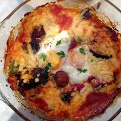 A picture of Baked eggs and aubergine in spicy sauce.