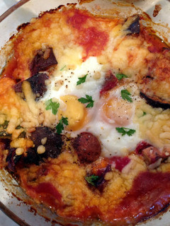 A picture of Baked eggs and aubergine in spicy sauce.