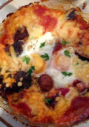 A picture of Baked eggs and aubergine in spicy sauce.