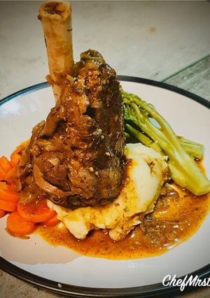A picture of Slow Cooked Lamb Shank with Garlic-Spring Onion Buttery Mashed Potatoes and Red Wine+Onion Jus.