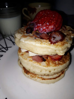 Una foto de Torre de pancakes con fresas y tocino
