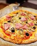 Pizza casera: prosciutto e fungi con olivas negras