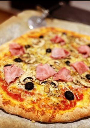 Una foto de Pizza casera: prosciutto e fungi con olivas negras