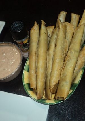 Una foto de Flautas de tortilla de harina con frijoles, chorizo y epazote, con mayonesa de chipotle el Geras