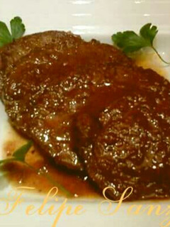 Una foto de Redondo de ternera relleno con pasas y piñones en salsa