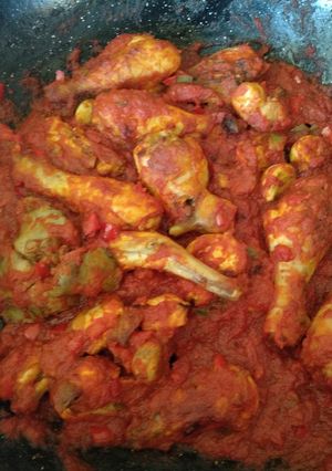 Una foto de Conejo y pollo con tomate a leña