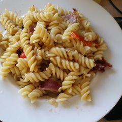 A picture of Pasta, bacon cheese and peppers.