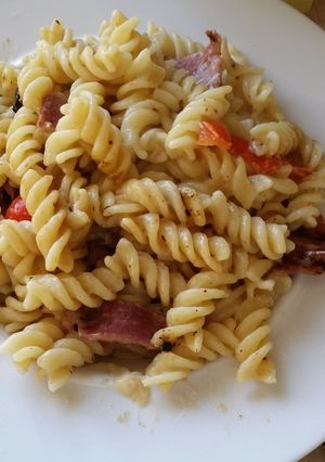 A picture of Pasta, bacon cheese and peppers.