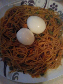 A picture of Jollof spaghetti with mix vegetable and boil egg.