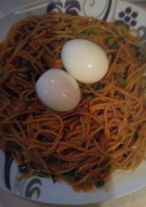 A picture of Jollof spaghetti with mix vegetable and boil egg.