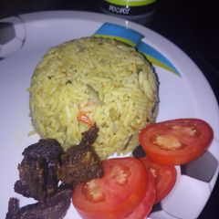 A picture of Vegetable Jolof rice with fried meat.