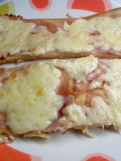 Una foto de Fainá de queso, cubierto de jamón y queso
