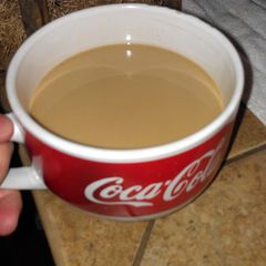 A picture of one cup, no coffee machine, coffee.