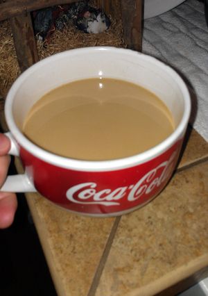 A picture of one cup, no coffee machine, coffee.