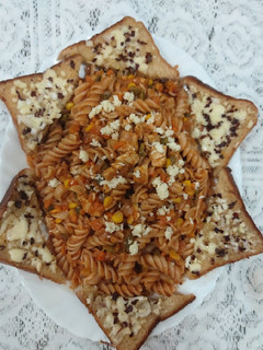 A picture of Red sauce chicken pasta with garlic bread.