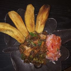 A picture of Fried plantains,with beef stew and a side of kachumbari(salsa).