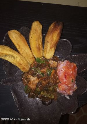 A picture of Fried plantains,with beef stew and a side of kachumbari(salsa).