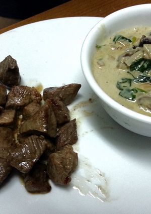 A picture of Lamb fillet with mushroom and spinach sauce.