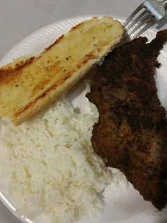 A picture of Fried steak with rice and garlic bread.