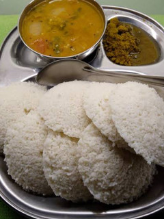 A picture of Idli sambar with coconut chutney.