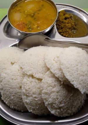 A picture of Idli sambar with coconut chutney.