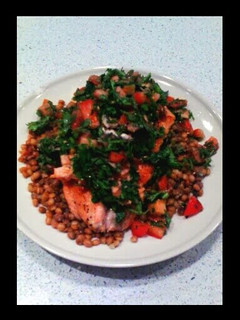 A picture of salmon with anchovies sauce and green lentils.