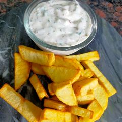 A picture of Ranch Dressing with Potato Wedges.
