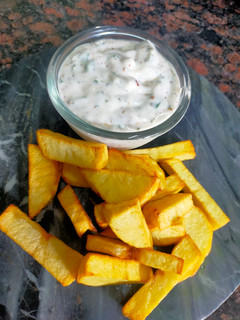 A picture of Ranch Dressing with Potato Wedges.