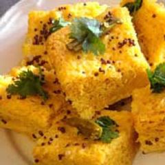 A picture of Dhokla with spicy tadka.