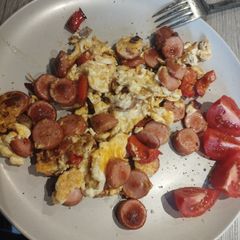 A picture of Best scrambled eggs with tomatoes on side.