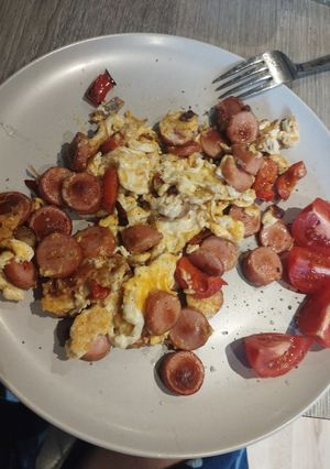 A picture of Best scrambled eggs with tomatoes on side.