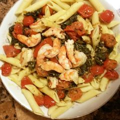 A picture of shrimp tomato spinach ziti.