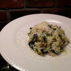 A picture of Risotto with thick slices of zucchini.